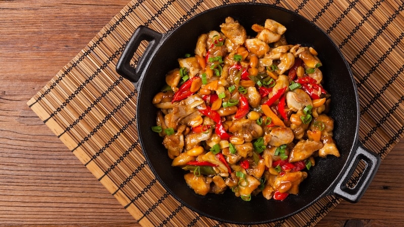 Chicken kung pao. Fried chicken pieces with peanuts and peppers. Top view. Flat lay.